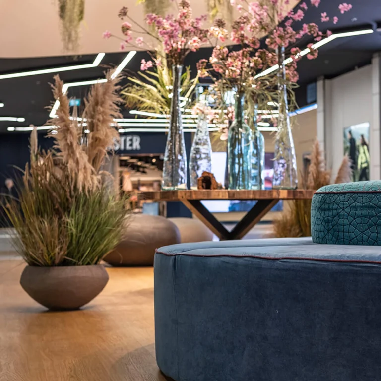 LAGO Center Dekoration Holztisch mit großen Vasen und Kirschblüten, davor weicher großer Pouf