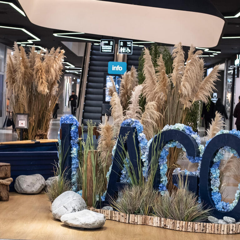 LAGO Center Dekoration Holzboot zwischen Sitzsteinen, Schilf und Holz-Logo
