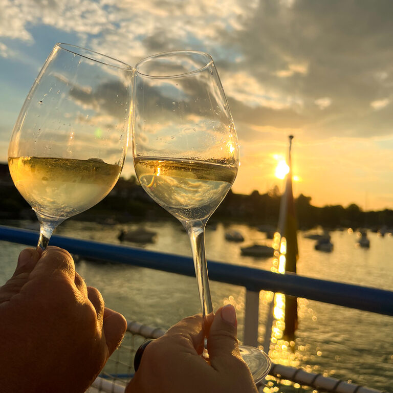 Gläser stoßen an bei Sonnenuntergang