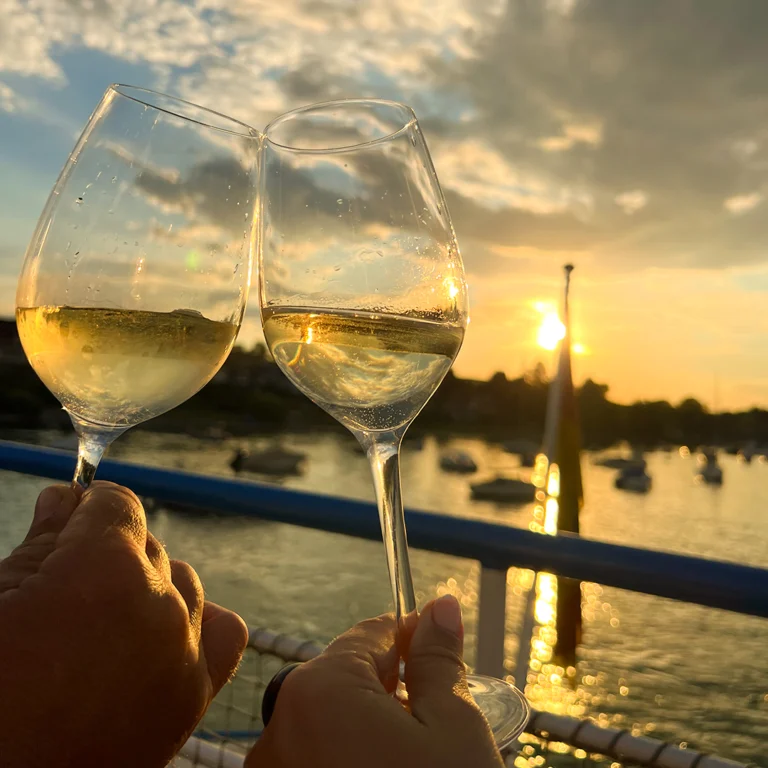 Gläser stoßen an bei Sonnenuntergang