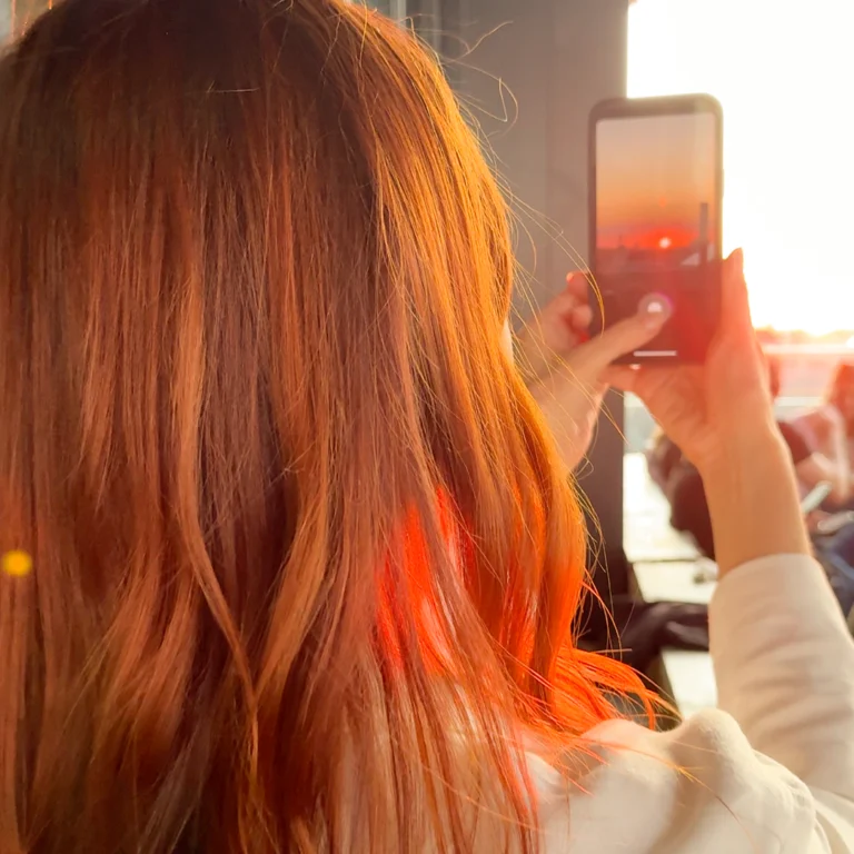 Frau macht Foto von Sonnenuntergang