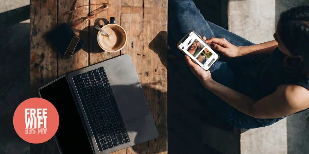 Frau am Tisch mit Kaffee, Laptop und Handy